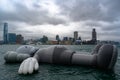 Art, Istallation, Floating Sculpture, Hong Kong. Gigantic dead grey mouse drifting on water at grey, cloudy day, Hong Kong Island